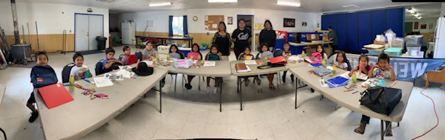 Children receiving school supplies in classroom